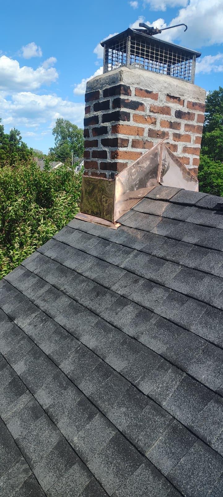 New copper chimney flashing installed on a shingle roof by EZ Roofing and Builders