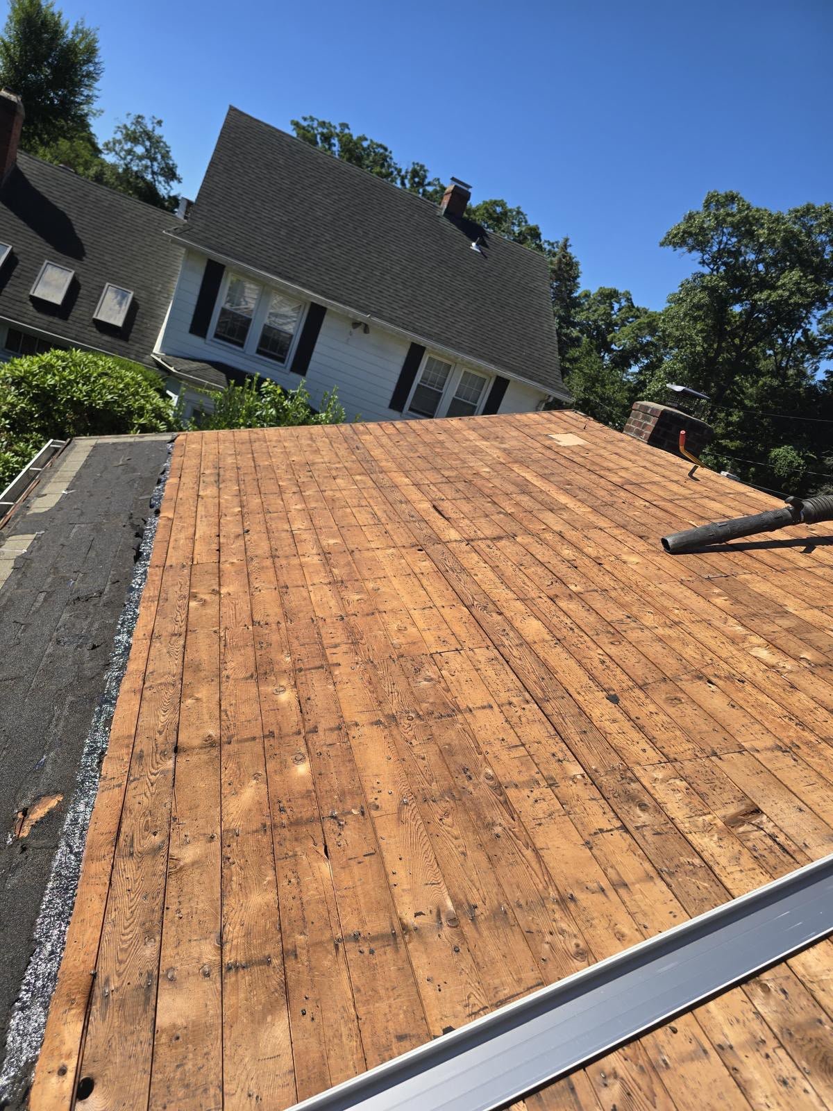Roof stripped back to bare wood decking during a full replacement by EZ Roofing and Builders